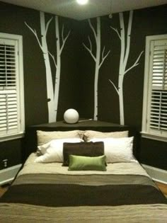 a bed room with a neatly made bed and white shutters on the window sill