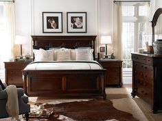 a bedroom with white walls and brown furniture