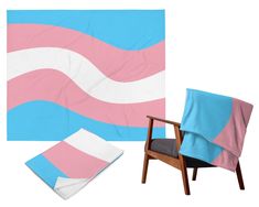 a chair and blanket sitting next to each other in front of a white backdrop with pink and blue stripes