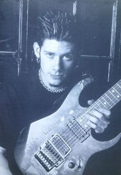 a young man holding an electric guitar in his hand