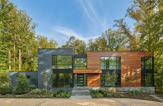 a large modern home surrounded by trees and bushes