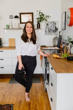 a woman standing in the middle of a kitchen