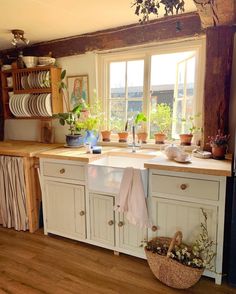 a kitchen filled with lots of counter top space next to a window and wooden floor