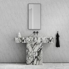 a marble sink in front of a mirror and coat rack on the wall next to it