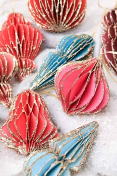 red, white and blue ornaments are sitting on snow