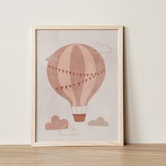 an art print of a hot air balloon flying in the sky with clouds on it