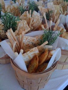 a basket filled with bread and vegetables on top of a table