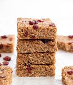 three bars stacked on top of each other with cranberries in the middle and oatmeal toppings