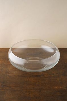 a clear bowl sitting on top of a wooden table