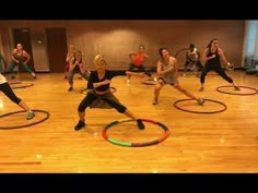 a group of people in a gym doing exercises with hula hoops