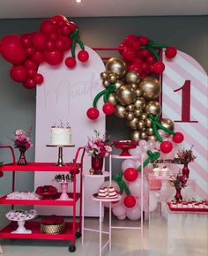 a birthday party with balloons, cake and desserts on display in front of the wall