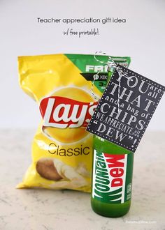 a bag of chips sitting next to a bottle of soda on top of a counter