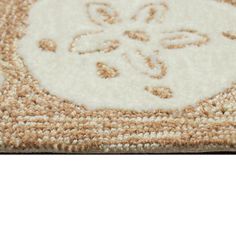 a close up of a rug on the floor with an intricate design in white and beige