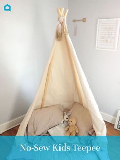 a teepee with a teddy bear in it on top of some blankets and pillows