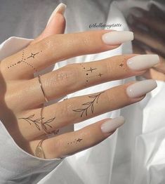 a woman's hand with three finger tattoos on her fingers and two stars in the middle