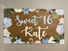 a sign that says sweet 16 rate with flowers and leaves painted on the side of it