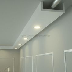 an empty room with white walls and recessed lighting on the ceiling is seen in this image