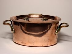 an old copper pot with handles on a white background