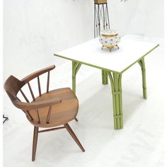 a table with two chairs and a cake on top of it next to a potted plant