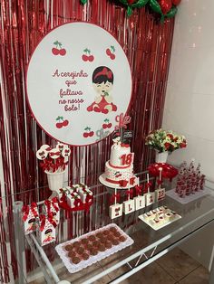 a table topped with cakes and cupcakes under a sign