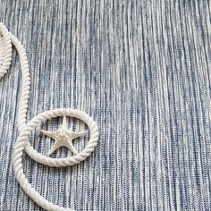 a white rope with a star on it is laying on a blue and white rug