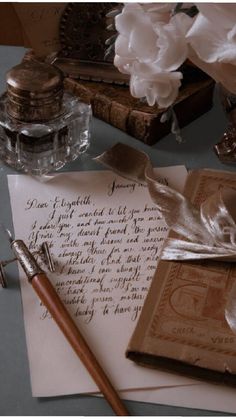 an old fashioned pen, inkwell and paper on a table