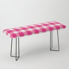 a pink and white checkered bench with metal legs