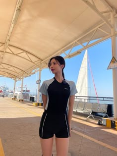 a woman standing under a white tent next to the ocean