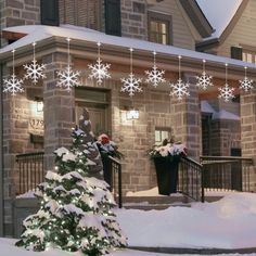 a house with snowflakes hanging from the roof and decorations on the front porch