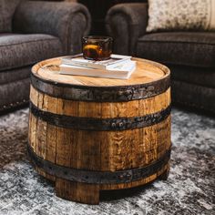 a wooden barrel coffee table sitting on top of a rug