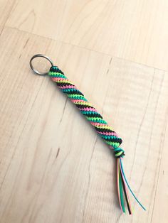 a multicolored keychain is on the floor with a pair of scissors