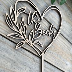 a heart shaped cake topper with the words into the becks on it and leaves