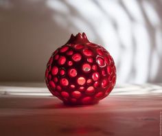 a red object sitting on top of a wooden table next to a white wall in the background