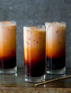 two glasses filled with liquid sitting on top of a table