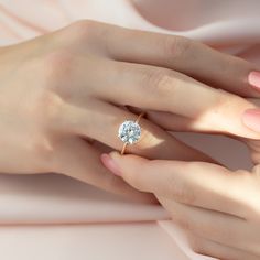 a woman's hand with a diamond ring on her finger