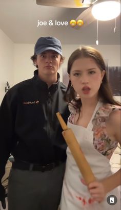 a man standing next to a woman holding a baseball bat