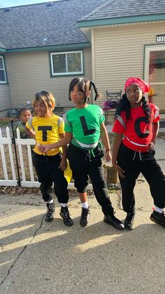 three children are standing in front of a house with numbers on their t - shirts