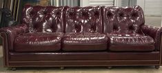 a red leather couch sitting inside of a room