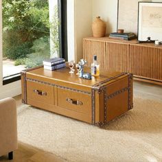 a living room filled with furniture and a large window overlooking the trees in the distance