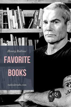 a man sitting in front of a bookshelf with his arms crossed and looking at the camera