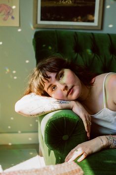 a woman laying on top of a green chair