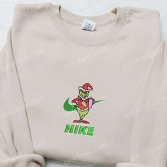 Introducing the Grinch With Pink Coffee Cup x Nike Embroidered Shirt and Christmas Embroidered Sweatshirt, the perfect gifts for your family this holiday season! Made with utmost precision, these shirts feature intricate embroidery of the Grinch holding a pink coffee cup, adding a playful and festive touch. Crafted with high-quality materials, they provide exceptional comfort and warmth. The unique collaboration between the Grinch and Nike ensures a stylish and trendy look for any occasion. With Candy Cane Nike Sweatshirt, Nike Iron On Grinch Sweatshirts, Grinch Nike Embroidery, Grinch Nike Hoodie, Pink Coffee Cup, Nike Inspired, Pink Coffee Cups, Best Family Gifts, Embroidered Shirts