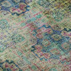 an area rug with many different colors and patterns on the carpet, including blue, green, pink, yellow