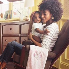 a woman sitting in a chair holding a small child with her arms around her neck