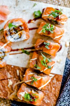 several sushi rolls are arranged on a platter with sauce and garnishes