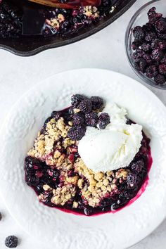 blueberry cobbler with ice cream and berries on the side, ready to be eaten