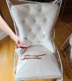 a person is holding a piece of furniture that has been wrapped in plastic