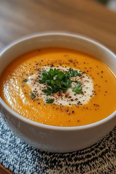 Creamy orange soup topped with a dollop of cream, parsley leaves, and black pepper in a white bowl. Light Lunch, Stew Recipes