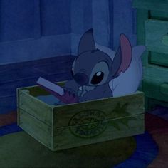 stitch in a wooden box on the floor next to a green dresser and blue wall