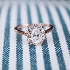 a close up of a diamond ring on a blue and white striped cloth with stripes